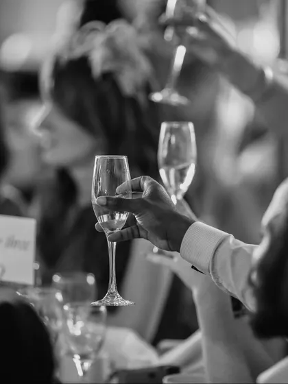 A toast to new beginnings. This black and white shot captures the joy and camaraderie of a celebration, a moment we are proud to facilitate with our seamless service and hospitality.