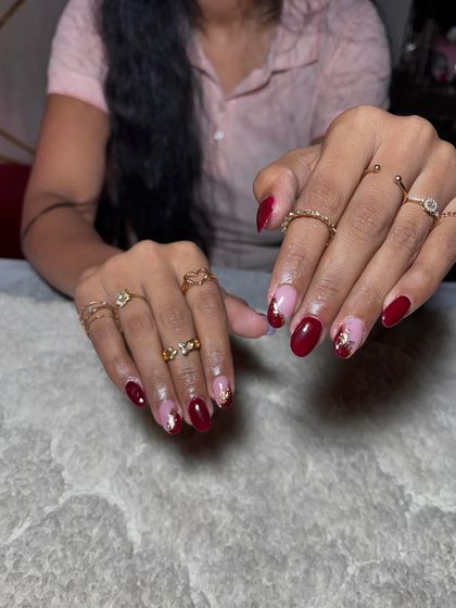 A beautiful combination of deep red and sparkling gold flakes on a nude base, perfect for a festive occasion.