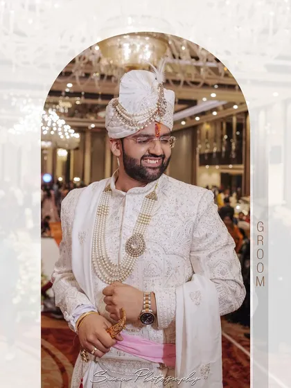 A creative portrait of the groom, framed within an arch shape, capturing his joyful expression.