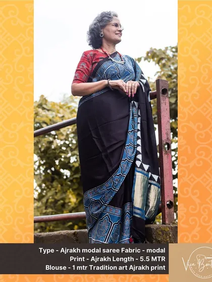 A customer looking poised and elegant in our black Ajrakh modal saree. The contrast of the red blouse brings out the beauty of the intricate block prints.
