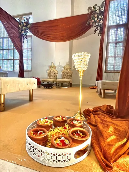 A detail shot showing traditional elements placed near the mandap, including earthen pots on a decorative tray, blending cultural rituals with our elegant decor.