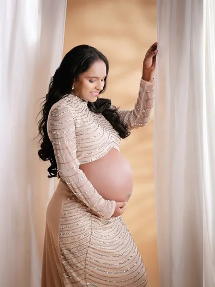An elegant and modern two-piece sequined outfit that beautifully showcases the bare baby bump.