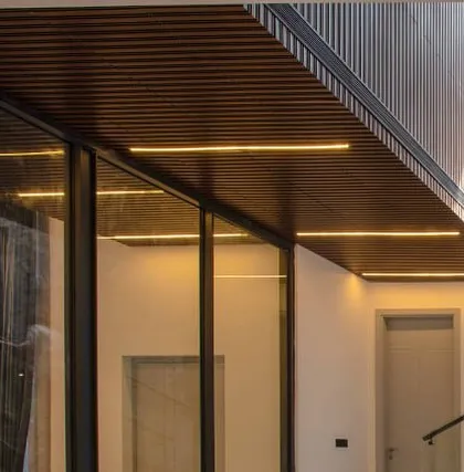A close-up of the ceiling detail in a corridor, where we have integrated linear lighting into a wooden slat ceiling for a clean, modern effect.