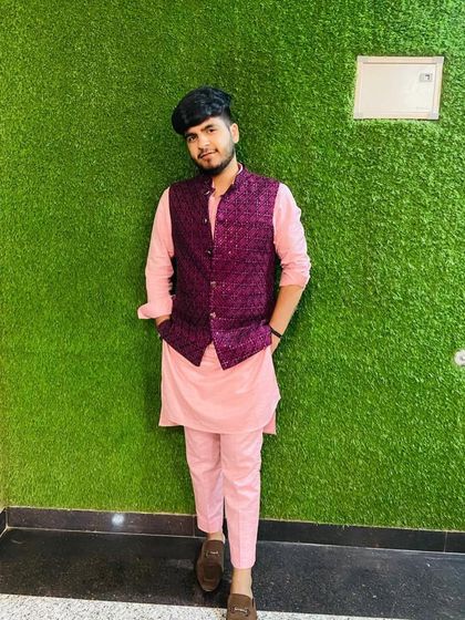 A stylish three-piece ethnic set featuring a pink kurta and pants with a contrasting purple patterned Nehru jacket. This is a great option for a Mehendi or Sangeet.