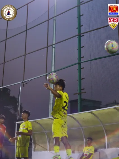 A young player practices his chest control during a night training session. We focus on mastering the fundamental skills from a young age.