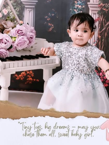 A little pianist in the making. This first birthday portrait features a baby girl in a sparkling dress at a miniature white piano, creating an elegant and memorable scene.