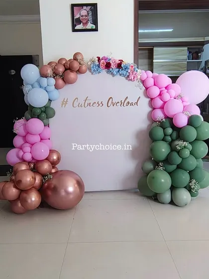 A versatile and modern balloon backdrop for a home celebration, with a customizable message like '#CutenessOverload' for a fun photo booth.