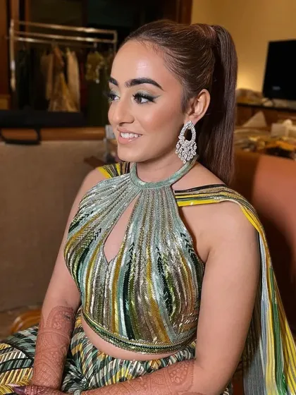 A side view of the sleek high ponytail. This hairstyle was chosen to complement the high-neck, futuristic design of the Amit Aggarwal lehenga.