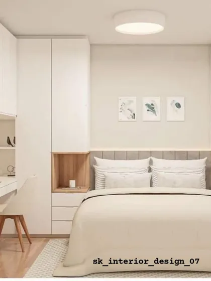 A functional bedroom layout that includes a wardrobe, overhead storage, and a small vanity or study desk. The combination of white and wood is timeless and versatile.