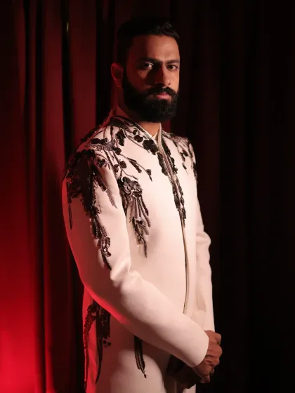 This client looks regal in a custom off-white bandhgala featuring striking black and silver embroidery on the shoulders and chest. It's a perfect example of contrast and craftsmanship.