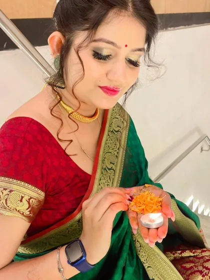 A candid shot capturing the festive spirit. The makeup is soft yet radiant, with glowing skin and defined eyes, holding up perfectly for all the rituals and celebrations.