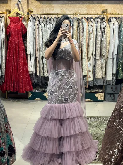 A mirror selfie showing off the full look of our lavender gown. You can see the beautiful floral embroidery and the elegant cape-style dupatta.