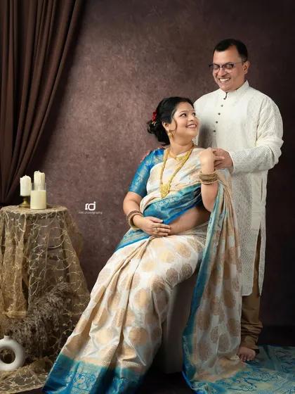 A joyful, smiling portrait of a couple in traditional attire. Their happy expressions and comfortable pose make this a heartwarming addition to their maternity album.