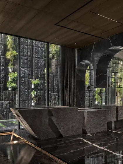 This bar counter at the Green Court Villa is sculpted from split stone, interacting with a water body below. It's a prime example of how I use raw materials to create functional art that engages the senses.