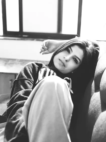 A close-up black and white portrait that feels intimate and direct, capturing a quiet moment.
