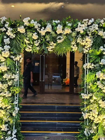 A beautiful and elegant floral archway made with white flowers and lush green foliage. This demonstrates our versatility and skill in creating stunning decor with materials beyond balloons, perfect for weddings and formal events.