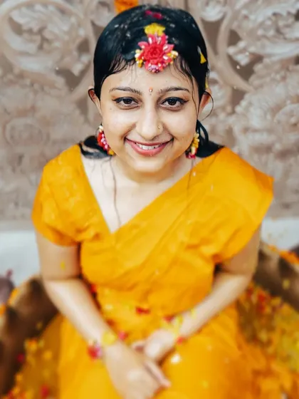 A lovely, direct portrait of the bride after the water ritual, her smile shining through.