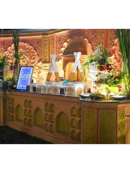 A custom-designed ice cream counter with unique acrylic stands, fitting perfectly with a grand, traditional Indian theme.