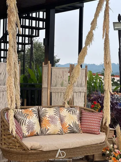 A close-up of the beautiful rattan swing decorated with pampas grass and patterned cushions, providing a perfect photo opportunity and a cozy spot to relax.