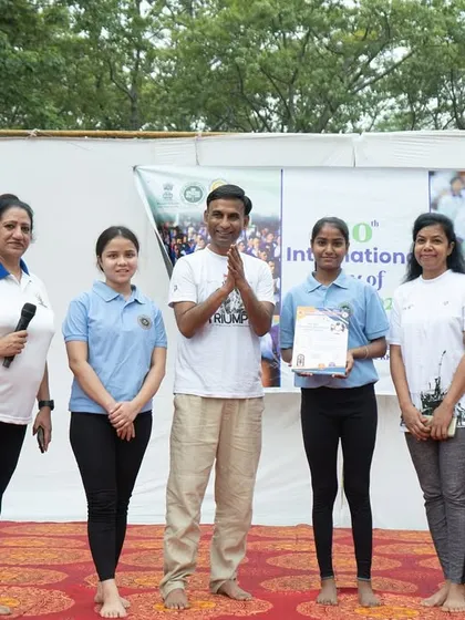 My team of students on stage with the event organizers, celebrating a successful International Day of Yoga.