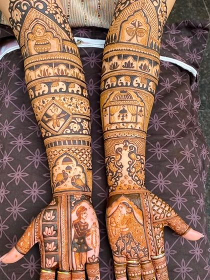 A stunning example of full-arm portrait mehndi. The design features the bride and groom on the palms, with detailed patterns and motifs covering the entire arm.