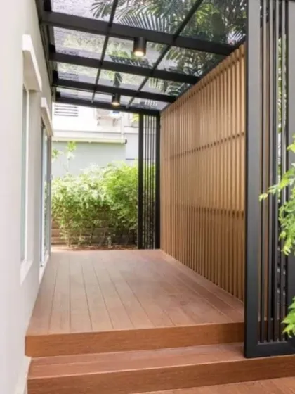 A cozy and modern balcony design. We used WPC decking for warmth and durability, complemented by a sleek glass and metal pergola and a slatted wooden screen for privacy, creating a perfect little urban escape.
