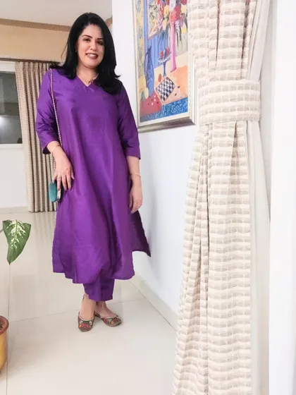 For an anniversary dinner, I chose this bright purple kurta set. The vibrant colour is celebratory, and I paired it with a green bag and juttis for a fun contrast.