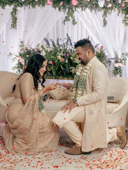 A tender moment from the ring ceremony, with flower petals showering the couple. This shot captures the romance and tradition of the engagement.