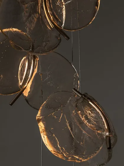 A close-up of the Bocci 141 series, showing the organic, leaf-like shape and textured surface of the hand-poured glass.