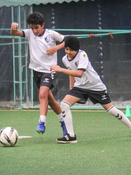 Two teammates work together to win the ball, an example of the defensive pressing and teamwork we practice.