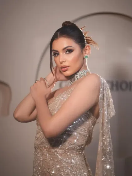A close-up of the champagne gown. The styling highlights the intricate beadwork and the modern, edgy hairstyle.