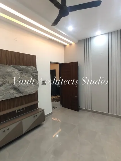 The same room, now with the TV unit installed. The design combines a wood-finish back panel with a striking marble-like feature and a sleek, modern console.