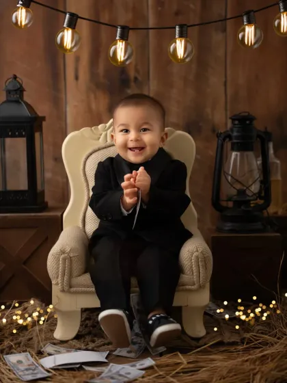 This little boss is all smiles, clapping his hands with glee. These prop-based photoshoots are perfect for capturing your toddler's playful side.