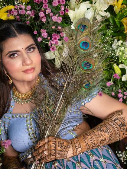 A truly artistic shot of the bride with peacock feathers, which echo the peacock motifs in her henna design. She looks absolutely radiant.