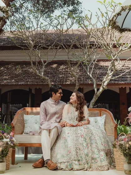 The happy couple, seated amidst the beautiful bohemian decor of their Mehendi. The natural textures and pastel florals create a perfect, romantic frame.