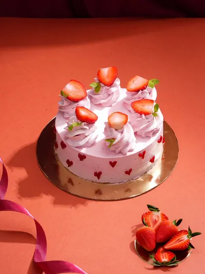 This charming strawberry cake is styled with a simple, colorful background and a flowing ribbon to create a celebratory feel. It’s a sweet and simple setup perfect for showcasing specialty cakes.