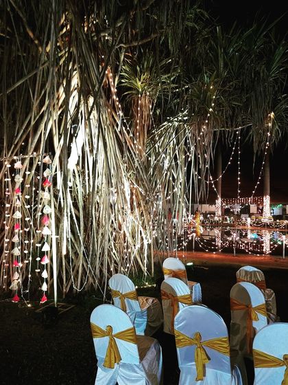 Another perspective of the decorated trees and seating area, showing how lighting can completely change the ambiance of an outdoor space after sunset.