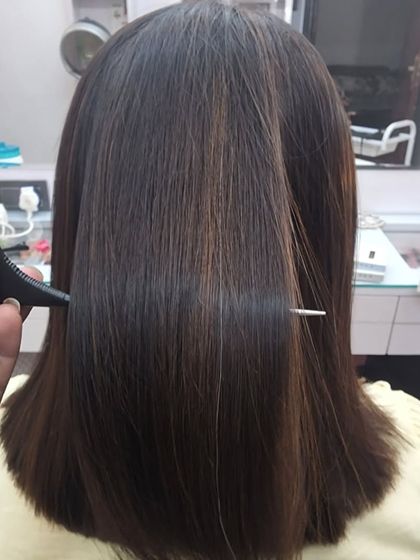 The final look after a highlights and Kerashine service. The hair is straight, glossy, and features subtle, natural-looking highlights, just as the client requested.
