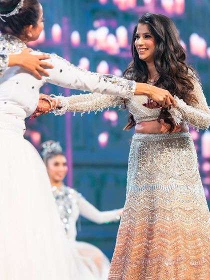 A candid moment of Natasha on the dance floor. The full-sleeve crop top and flowing lehenga were designed for both style and movement.