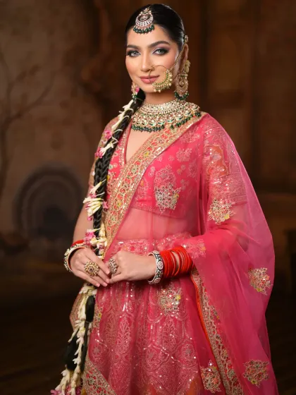 This shot highlights the harmony between the makeup, the vibrant pink lehenga, and the intricate jewelry. The look is regal, striking, and perfectly balanced.