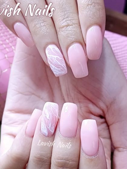 A soft pink set with a subtle white marble or rose quartz effect on the accent nails.