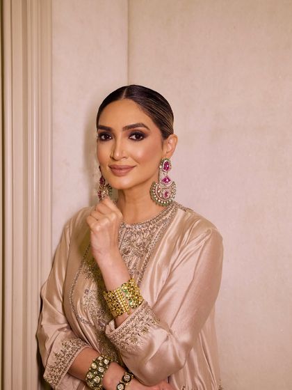 A close-up of the client, her statement earrings and bold makeup creating a high-fashion look.