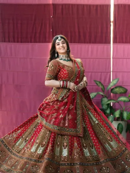Another beautiful shot of the bride, twirling in her red lehenga. The makeup is designed to be effortless and elegant, perfect for a magazine feature.