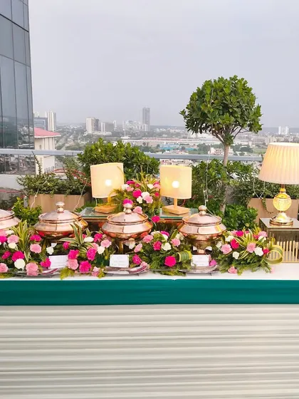 A beautiful rooftop buffet setup overlooking the city skyline. We specialize in transforming unique outdoor spaces into stunning dining venues, complete with elegant floral arrangements and ambient lighting.