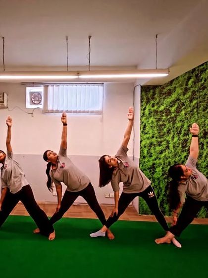 A group of employees practicing Trikonasana (Triangle Pose). This is a great pose for office workers as it stretches the sides of the body and opens the chest.