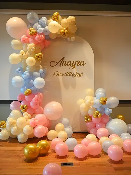 Welcome your little one with an elegant and modern baby shower decoration. This setup for Anayra features a beautiful pastel balloon arrangement in pink, blue, and cream, with a custom arched backdrop that adds a personal and sophisticated touch.