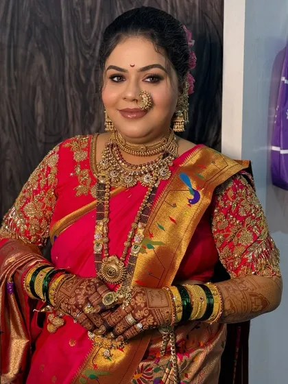 A full portrait of the bride in her pink Paithani, looking radiant and joyful.