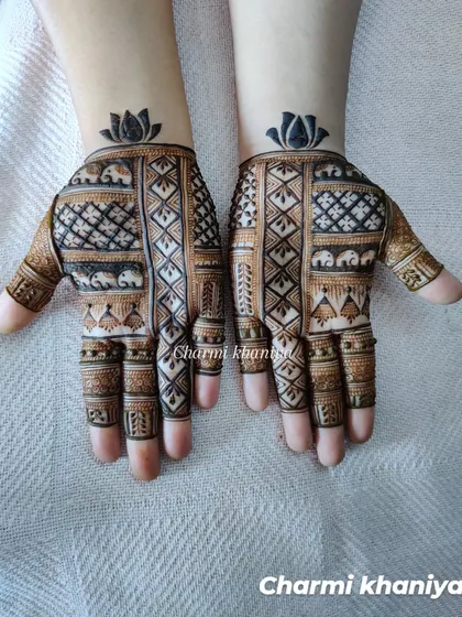 A beautiful and elegant mehendi design chosen by the client. This piece combines geometric grids with tiny elephant figures and is topped with a bold lotus at the wrist.