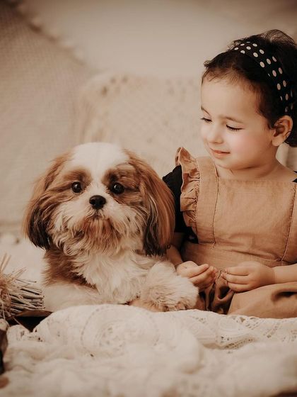 A sepia-toned portrait of a little girl with her adorable Shih Tzu. We welcome furry friends in our sessions to capture the special bond between children and their pets.