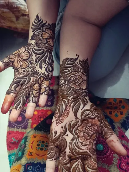 This design features large, open floral patterns on the back of the hands, a hallmark of the Arabic mehendi style. It's an elegant choice for any occasion.
